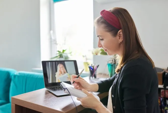 Female teacher at home with laptop on virtual meeting with teenage student